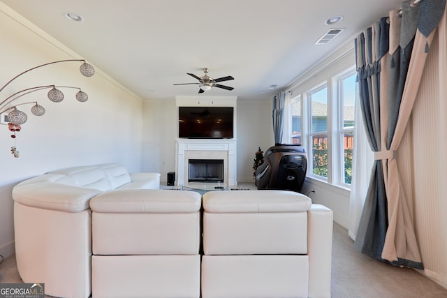 carpeted living room with crown molding and ceiling fan