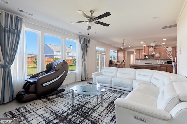 living room featuring ornamental molding and ceiling fan