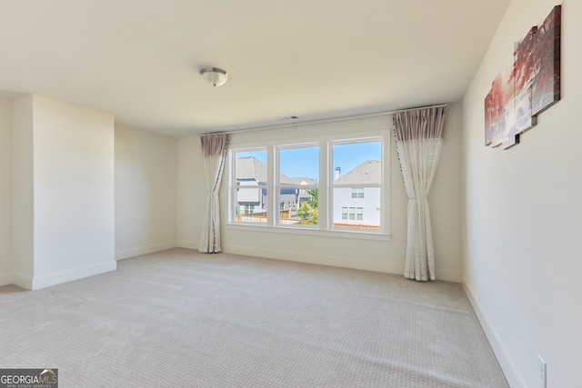 spare room featuring light colored carpet