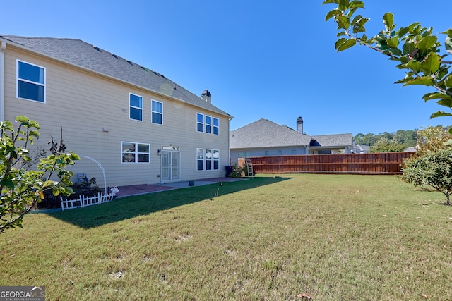 rear view of house featuring a yard and a patio area