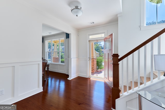 entryway featuring ornamental molding and dark hardwood / wood-style floors