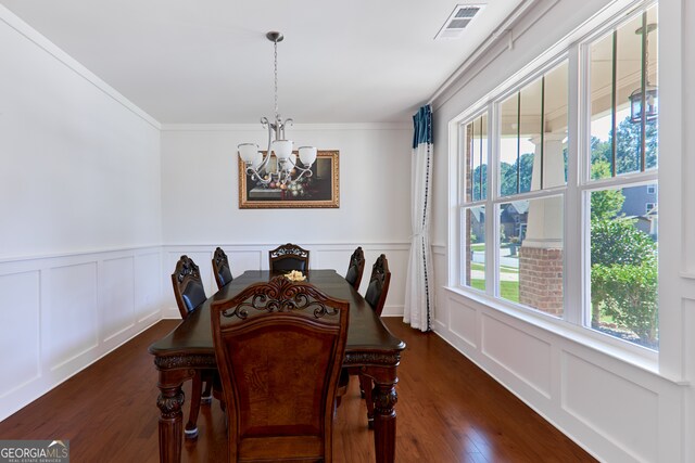 dining room featuring ornamental molding, a notable chandelier, plenty of natural light, and dark hardwood / wood-style floors