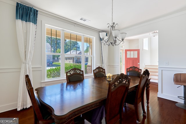 dining area featuring a notable chandelier, crown molding, and dark wood-type flooring