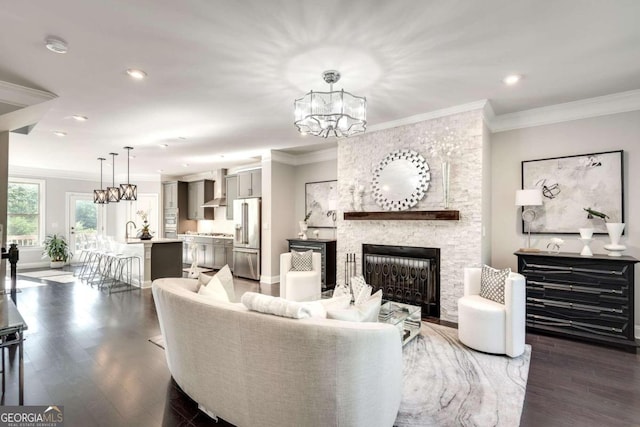 living room featuring a stone fireplace, dark hardwood / wood-style floors, and crown molding