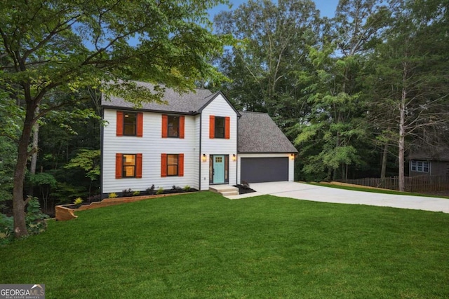 colonial house featuring a front yard and a garage