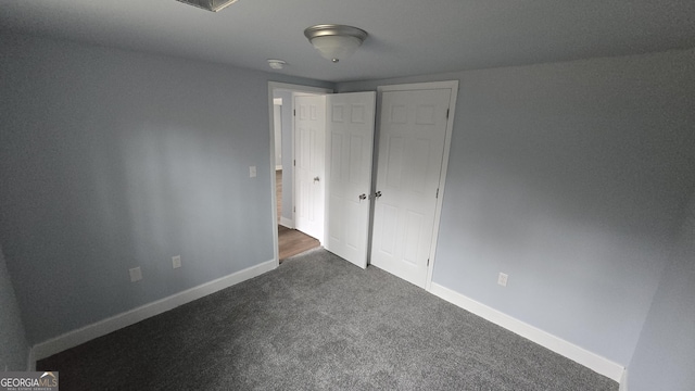 unfurnished bedroom featuring dark carpet