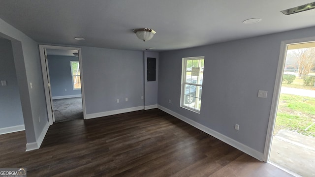 unfurnished room with dark hardwood / wood-style flooring, plenty of natural light, and electric panel