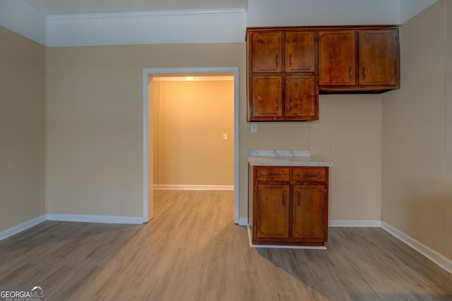 kitchen featuring crown molding and light wood-type flooring