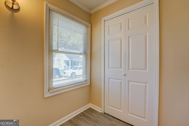 interior space with a closet, light hardwood / wood-style floors, and ornamental molding