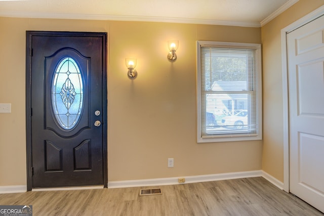 entrance foyer featuring light hardwood / wood-style floors, crown molding, and a wealth of natural light