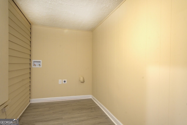 washroom with washer hookup, a textured ceiling, wood-type flooring, ornamental molding, and hookup for an electric dryer