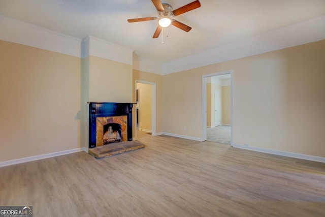 unfurnished living room featuring light hardwood / wood-style floors, a stone fireplace, and ceiling fan