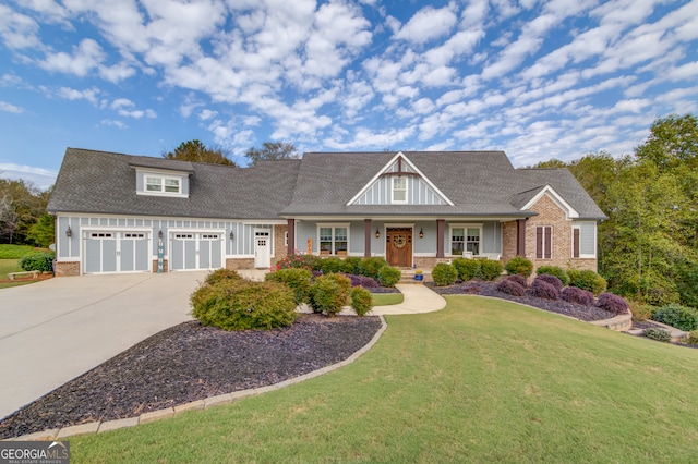 view of front of home with covered porch, a garage, and a front lawn