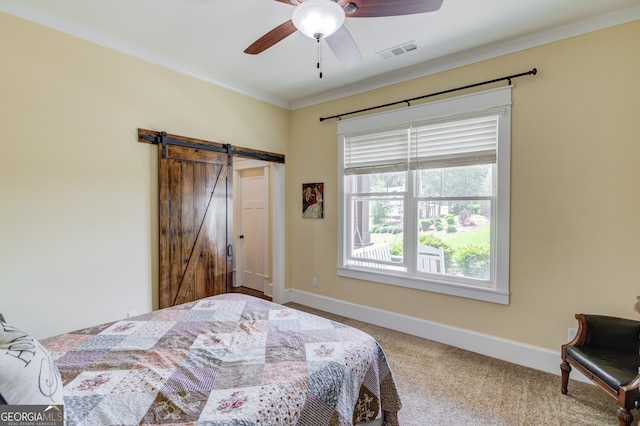 carpeted bedroom featuring ornamental molding, a barn door, and ceiling fan