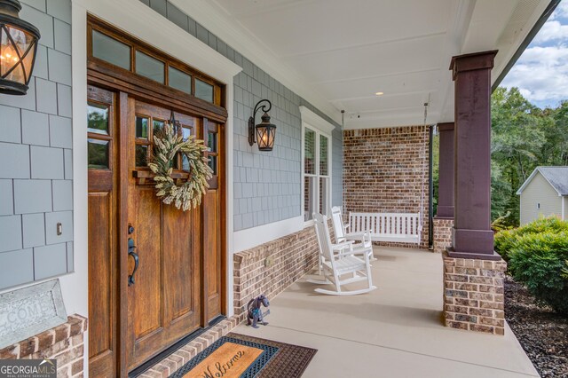 entrance foyer featuring dark hardwood / wood-style flooring, ceiling fan, ornate columns, and plenty of natural light