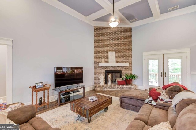 living room featuring ornamental molding, beam ceiling, and wood-type flooring