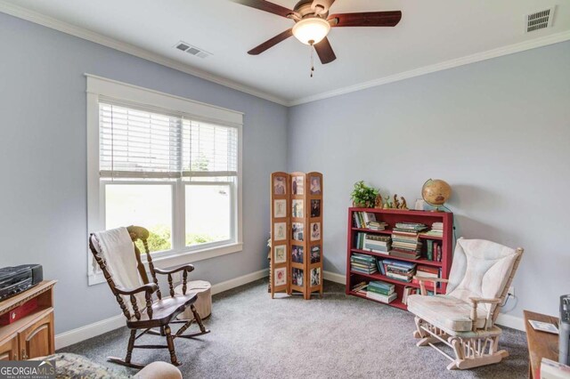 sitting room with ceiling fan, ornamental molding, and carpet floors