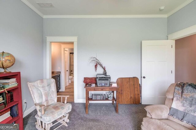 living area featuring crown molding and dark colored carpet