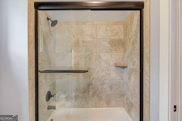 bathroom featuring bath / shower combo with glass door