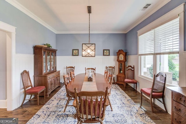 dining space with dark wood-type flooring and crown molding