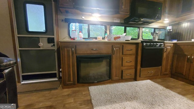 kitchen featuring hardwood / wood-style floors and black appliances