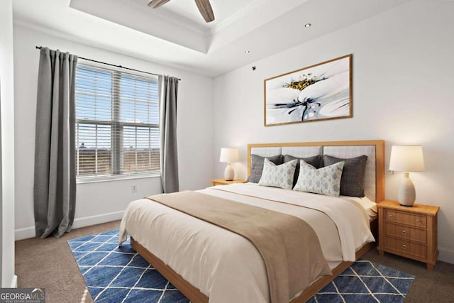 bedroom with dark carpet, ornamental molding, a raised ceiling, and ceiling fan