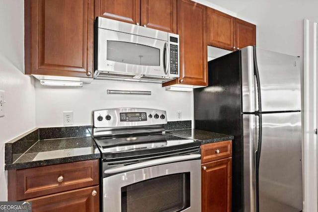 kitchen featuring appliances with stainless steel finishes and dark stone countertops