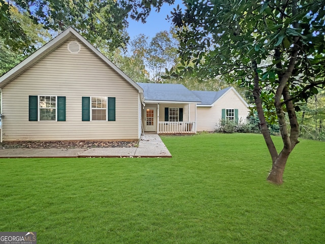 rear view of property with a yard