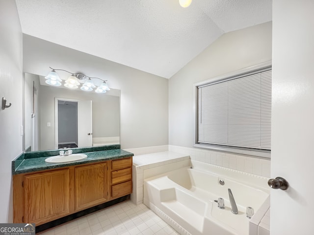 bathroom with a bathing tub, lofted ceiling, a textured ceiling, vanity, and tile patterned floors