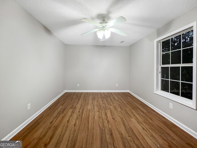 empty room featuring a textured ceiling, wood-type flooring, and ceiling fan