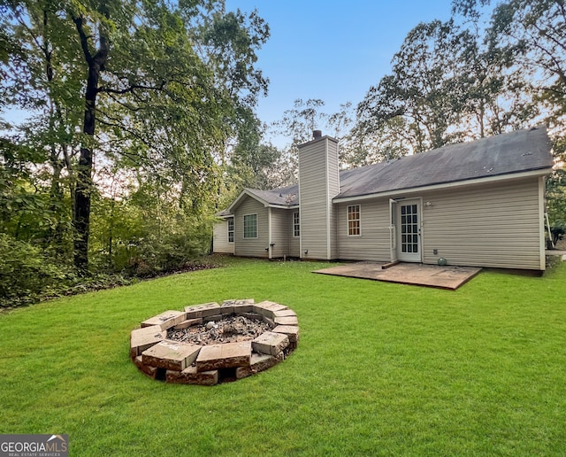 back of house with a patio, a fire pit, and a lawn