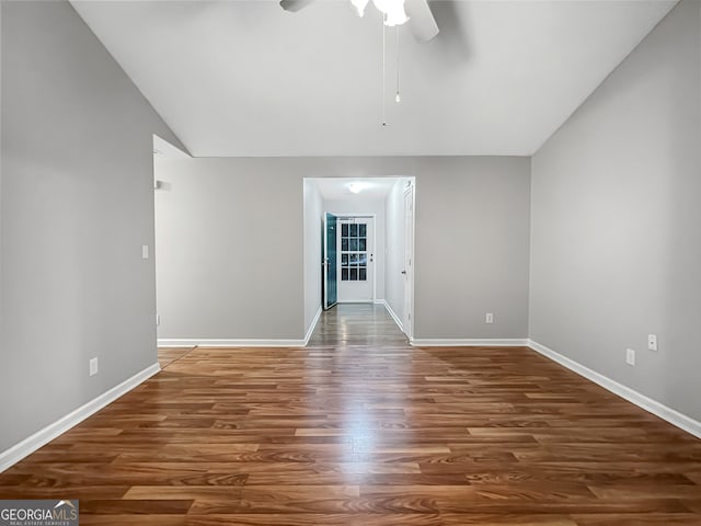 unfurnished room with ceiling fan, vaulted ceiling, and dark hardwood / wood-style flooring