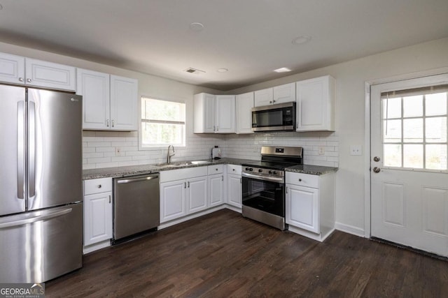 kitchen featuring stone countertops, appliances with stainless steel finishes, and dark hardwood / wood-style flooring