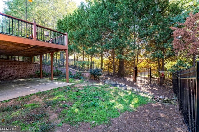 view of yard featuring a patio and a wooden deck