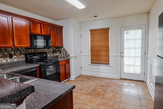 516 Jaclyn Cir, Mcdonough, GA 30253 - kitchen featuring black appliances, dark countertops, backsplash, light tile patterned floors, and wainscoting