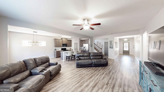 living room with light wood-type flooring and ceiling fan