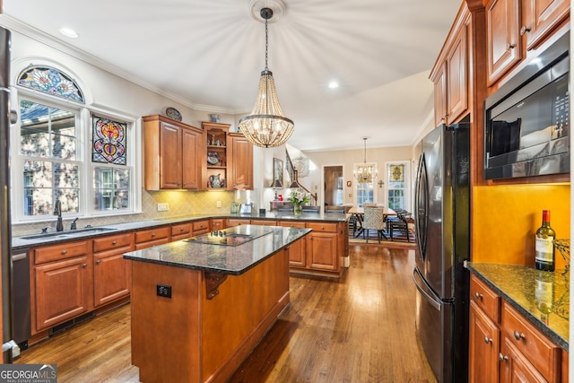 kitchen with stainless steel appliances, sink, a center island, a chandelier, and dark hardwood / wood-style flooring