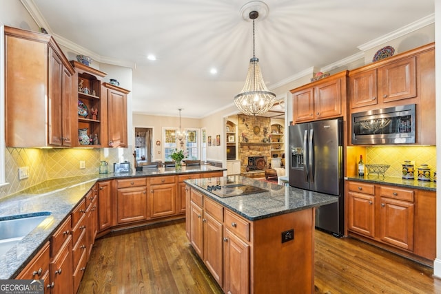 kitchen featuring a kitchen island, appliances with stainless steel finishes, dark wood-type flooring, pendant lighting, and a notable chandelier