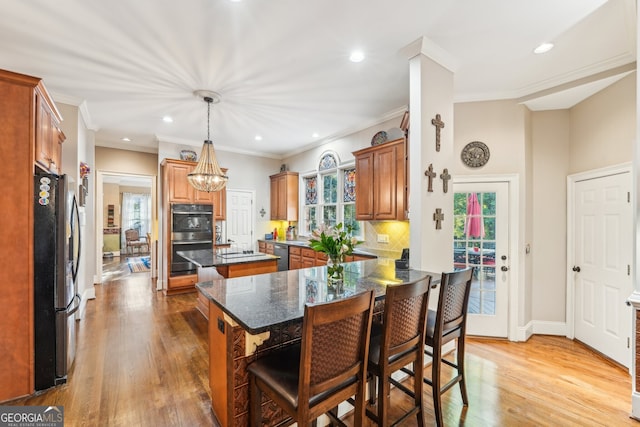 kitchen featuring a center island, appliances with stainless steel finishes, a wealth of natural light, and light wood-type flooring