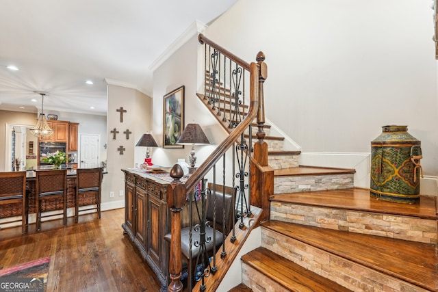 staircase featuring ornamental molding and wood-type flooring