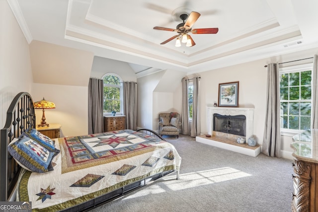 carpeted bedroom featuring ceiling fan, ornamental molding, and a tray ceiling