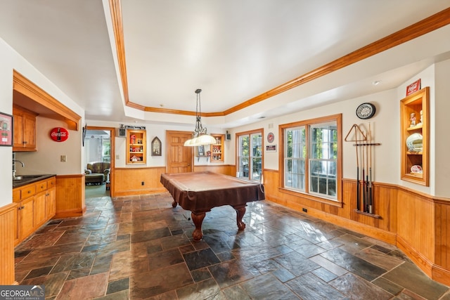 recreation room featuring pool table, a raised ceiling, wooden walls, crown molding, and sink