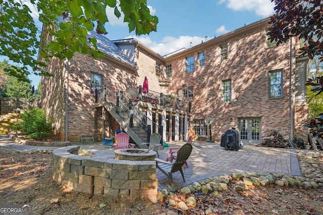 back of house with a patio, french doors, a wooden deck, and a fire pit