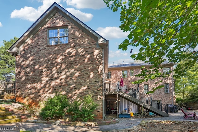 view of property exterior with a patio and a deck