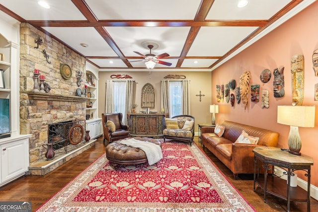 living room featuring beamed ceiling, dark wood-type flooring, a stone fireplace, and coffered ceiling