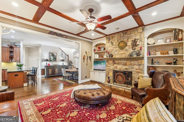 living room featuring coffered ceiling, beam ceiling, hardwood / wood-style floors, built in shelves, and a fireplace