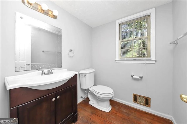 bathroom featuring vanity, toilet, a textured ceiling, and hardwood / wood-style floors