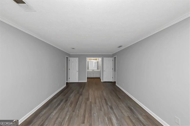 empty room with crown molding and dark hardwood / wood-style flooring