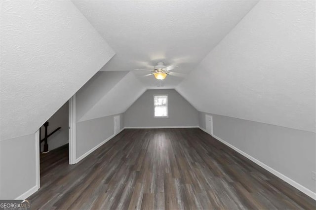 bonus room with a textured ceiling, vaulted ceiling, and dark hardwood / wood-style floors