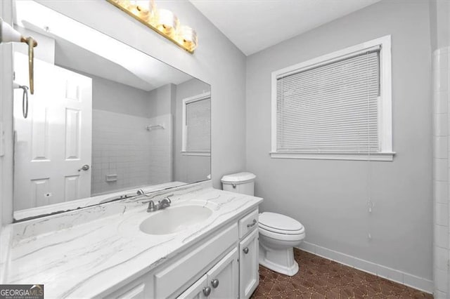 bathroom featuring vanity, walk in shower, and toilet